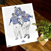 Unframed word art print depicting players celebrating Chicago Cubs 2016 World Series win lies flat on wooden table.