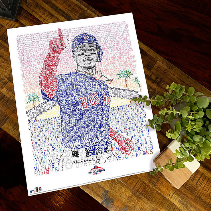 Unframed word art print of 2018 Boston Red Sox outfielder Mookie Betts in World Series lies flat on wood table next to plant.