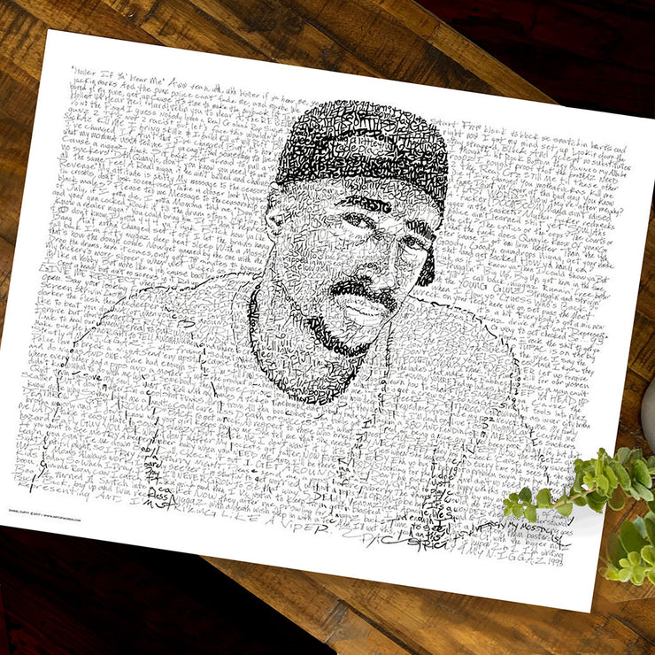 Unframed print of word art Tupac drawing formed by handwritten rap lyrics lies flat on wooden table next to small plant.