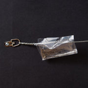Wire hanger with plastic bag containing nail and hook on back of framed illustrated Citizens Bank Park artwork.