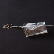Wire hanger with plastic bag containing nail and hook on back of framed Penn State Football Stadium print.