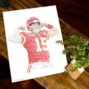  Patrick Mahomes gift portrait with red, yellow, white words from Kansas City Chiefs art collection by Dan Duffy on table.