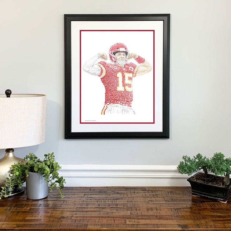 Framed Patrick Mahomes gift portrait with red, yellow, white words from Kansas City Chiefs art collection above a dresser. 