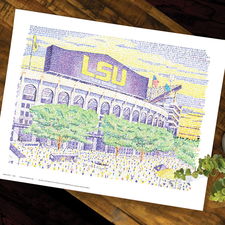  Purple and yellow LSU Tiger artwork of LSU stadium and green trees comprised of words on wood table.