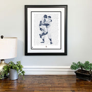 Matted and framed handwritten word art of Don Larsen’s 1956 World Series perfect game hangs on wall over wood table.