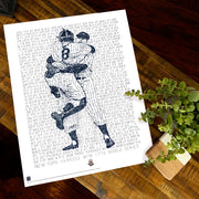 Unframed word art print of Don Larsen and Yogi Berra celebrating 1956 World Series perfect game lies flat on wooden table.