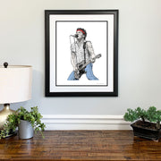 Framed Bruce Springsteen art print hangs on wall above wooden table, one of the great Bruce Springsteen gifts.