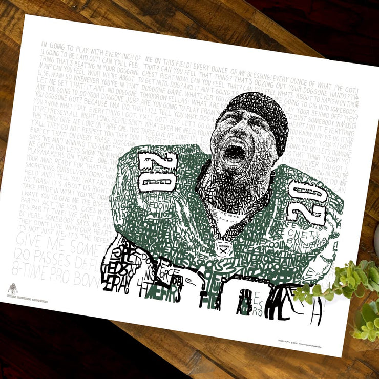 Unframed word art print of Philadelphia Eagles’ Brian Dawkins lies flat on wooden table next to small plant.