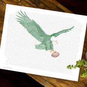 Print of green eagle with brown football made of handwritten words of Philadelphia Eagles rosters (1933-2018) on wood table.