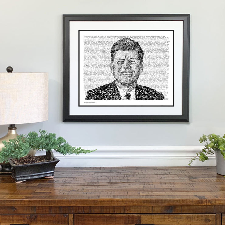Matted, framed word art portrait of John F. Kennedy hangs on wall above wood table—one of the best JFK gifts.