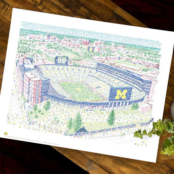 Color illustration made of hand-written words of ariel view of the big house Michigan Stadium on wood table.