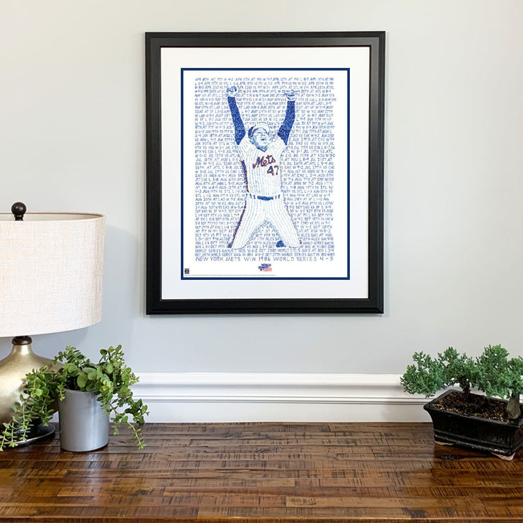 Matted and framed handwritten word art of Jesse Orosco celebrating 1986 World Series win hangs on wall over wood table.