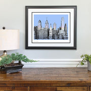 Framed Philadelphia gift art of city skyline made of handwritten words of Philly landmarks and more on wall above dresser.